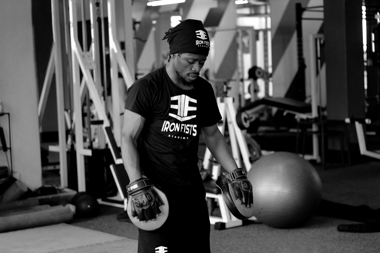 Iron Fists coach holding focus pads during training